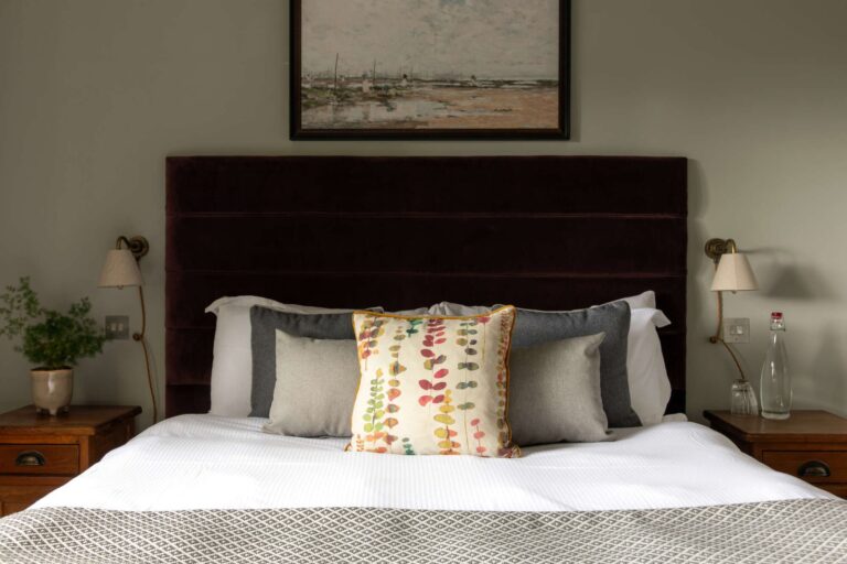 Double bed and bedside lamps in a guest room at The Carpenter’s Arms