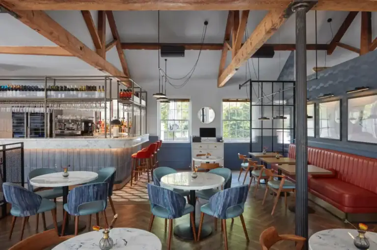 Dining room and bar at The Brasserie at Darleys, with timber beams and blue seating