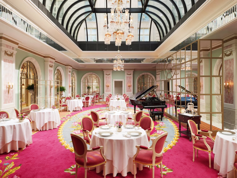 The Ritz Restaurant dining room with chandeliers, a glass roof and formally laid tables